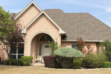 Design ideas for a large traditional one-storey brick house exterior in Dallas with a hip roof, a shingle roof and a grey roof.