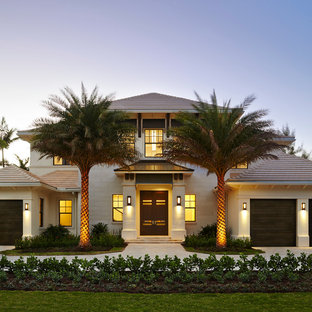 マイアミのトロピカルスタイルのおしゃれな家の外観 (漆喰サイディング、寄棟屋根) の写真