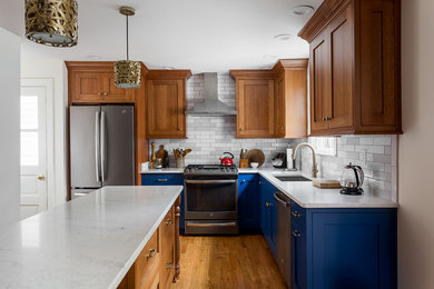 Inspiration for a small traditional l-shaped eat-in kitchen in Louisville with an undermount sink, shaker cabinets, blue cabinets, quartz benchtops, grey splashback, subway tile splashback, stainless steel appliances, light hardwood floors, brown floor, white benchtop and with island.