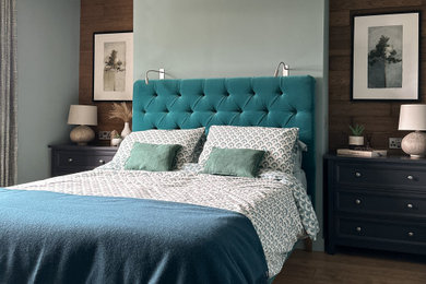 Foto de dormitorio principal clásico de tamaño medio con paredes azules, suelo laminado, suelo marrón y panelado