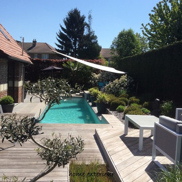 Abords d'une piscine avec plusieurs terrasses et massifs à Lesquin