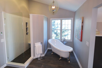 Inspiration for a large modern master gray tile and porcelain tile porcelain tile bathroom remodel in Indianapolis with flat-panel cabinets, dark wood cabinets, a one-piece toilet, gray walls, an undermount sink and solid surface countertops