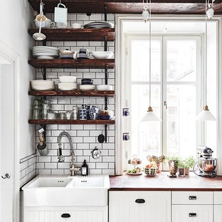 Industrial kitchen pantry inspiration - Inspiration for an industrial kitchen pantry remodel in Stockholm with a double-bowl sink, open cabinets, dark wood cabinets, wood countertops, white backsplash and porcelain backsplash