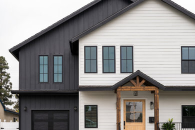 Huge beach style two-story house exterior photo in Los Angeles with a black roof