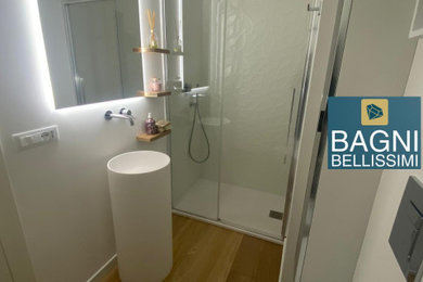 Foto di una stanza da bagno moderna con piastrelle bianche, piastrelle in gres porcellanato, parquet chiaro, porta doccia scorrevole e mobile bagno freestanding
