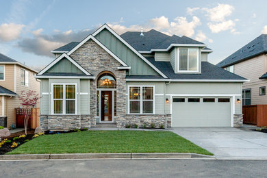 Elegant green two-story stone house exterior photo in Portland with a shingle roof