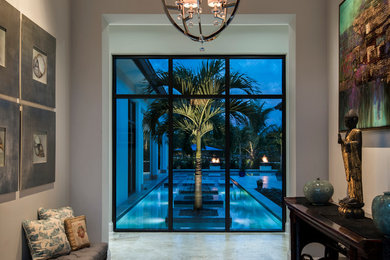 Design ideas for a mid-sized transitional foyer in Miami with grey walls and travertine floors.