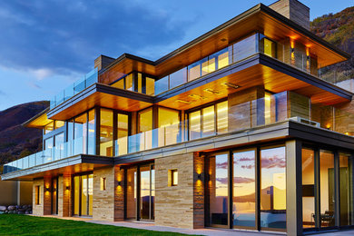 Example of a large trendy beige three-story mixed siding exterior home design in Denver with a hip roof