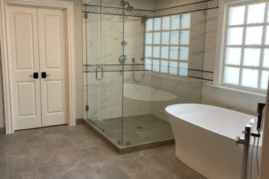 Double shower - french country gray floor and coffered ceiling double shower idea in Atlanta with a hinged shower door and a niche