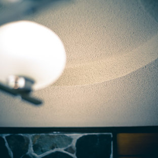 Immagine di una piccola camera matrimoniale etnica con pareti marroni, pavimento in legno verniciato, nessun camino e pavimento marrone