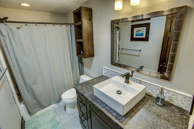 Tub/shower combo - modern kids' white tile and stone tile porcelain tile and gray floor tub/shower combo idea in Boise with shaker cabinets, dark wood cabinets, gray walls, a vessel sink and granite countertops