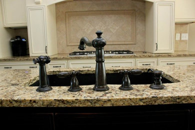 Inspiration for a large contemporary single-wall medium tone wood floor eat-in kitchen remodel in Other with a drop-in sink, raised-panel cabinets, white cabinets, beige backsplash and an island
