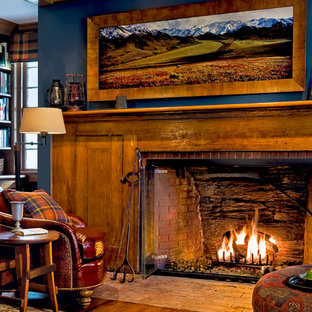 Design ideas for a traditional home office in New York with blue walls, medium hardwood floors, a brick fireplace surround and a standard fireplace.