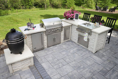 Example of a mid-sized trendy backyard stone patio kitchen design in Boise with no cover