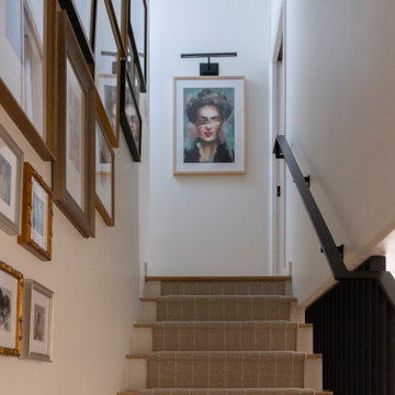 Entry Stairway Featuring White & Tan Runner, Abstract Art, and Black Wall Sconce