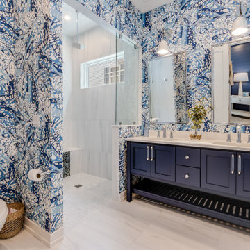 Bathroom with vibrant, unique wallpaper and navy blue vanity
