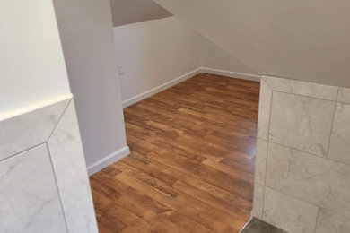 Mid-sized transitional gender-neutral laminate floor and brown floor walk-in closet photo in New York