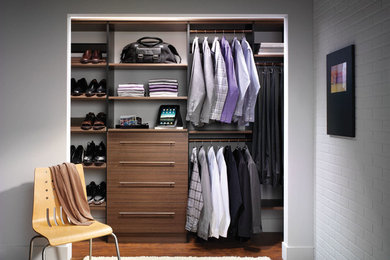 This is an example of a small contemporary men's built-in wardrobe in New Orleans with open cabinets, medium wood cabinets, medium hardwood floors and brown floor.