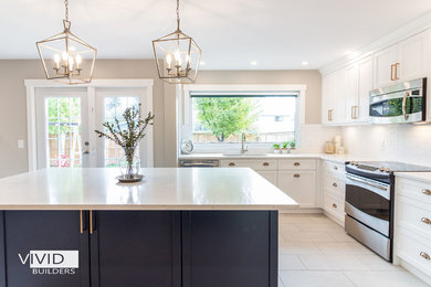 Example of a large cottage u-shaped porcelain tile and gray floor kitchen design in Calgary with an undermount sink, shaker cabinets, white cabinets, quartz countertops, white backsplash, ceramic backsplash, stainless steel appliances, an island and white countertops