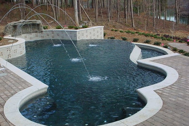 Example of a side yard brick and custom-shaped pool fountain design in Other
