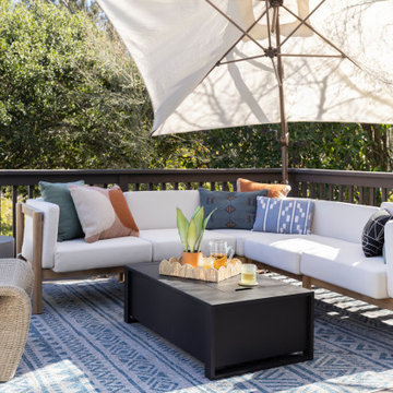 Outdoor Deck with White Cushioned Sectional, Fire Coffee Table, and Patterned Ru