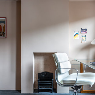 Inspiration for a medium sized bohemian look-out basement in London with pink walls, concrete flooring, no fireplace, a plastered fireplace surround and grey floors.