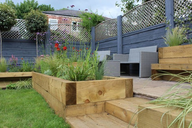 This is an example of a medium sized contemporary back formal partial sun garden in Manchester.