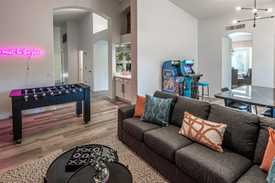 Modelo de sala de estar abierta clásica renovada grande con paredes blancas, suelo de baldosas de porcelana, televisor colgado en la pared y suelo gris