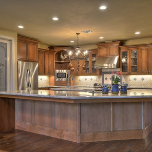 Craftsman kitchen pantry ideas - Arts and crafts l-shaped kitchen pantry photo in Sacramento with brown cabinets, granite countertops, ceramic backsplash, stainless steel appliances, an island and beige backsplash