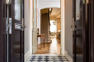 Double front door - traditional marble floor double front door idea in New York with a dark wood front door and gray walls