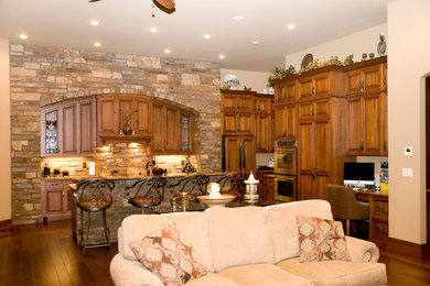 Inspiration for a large transitional l-shaped open concept kitchen remodel in Cedar Rapids with a farmhouse sink, raised-panel cabinets, medium tone wood cabinets, granite countertops, stainless steel appliances and an island