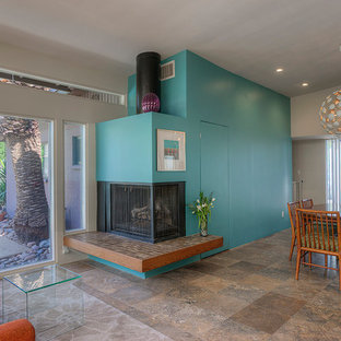 Idee per un piccolo soggiorno minimalista aperto con pareti grigie, pavimento in travertino, camino ad angolo e nessuna TV