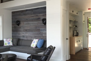 Example of a mid-sized trendy loft-style medium tone wood floor living room design in Toronto with white walls, a corner fireplace and a wood fireplace surround