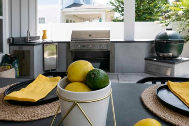 Patio kitchen - mid-sized contemporary backyard concrete paver patio kitchen idea in Jacksonville with a roof extension