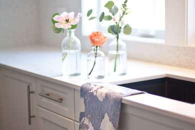 Inspiration for a mid-sized farmhouse u-shaped dark wood floor open concept kitchen remodel in Calgary with an undermount sink, shaker cabinets, white cabinets, quartz countertops, white backsplash, ceramic backsplash, stainless steel appliances and an island