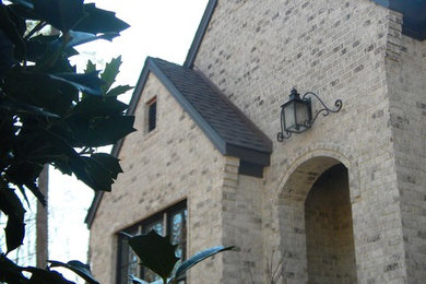 Large mediterranean beige two-story brick gable roof idea in Birmingham