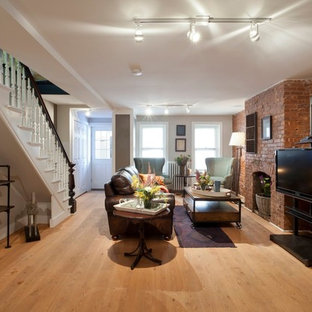 ニューヨークのトラディショナルスタイルのおしゃれな地下室 (半地下 (ドアあり)、グレーの壁、淡色無垢フローリング、標準型暖炉、レンガの暖炉まわり) の写真