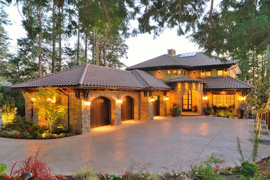 Large mediterranean beige two-story stone exterior home idea in Vancouver with a hip roof