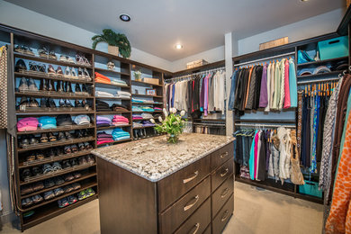 Example of a large transitional gender-neutral carpeted walk-in closet design in Other with flat-panel cabinets and dark wood cabinets