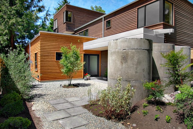 This is an example of a large contemporary three-storey multi-coloured house exterior in Seattle with wood siding and a flat roof.