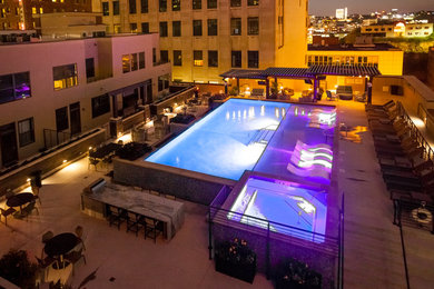 Example of a large minimalist rooftop rectangular lap pool fountain design in Kansas City with decking