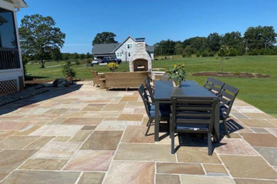 Large minimalist backyard stone patio photo in Richmond with a fireplace and no cover
