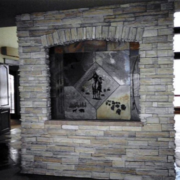 Slate water wall with etched western scene on the back of a drystack fireplace
