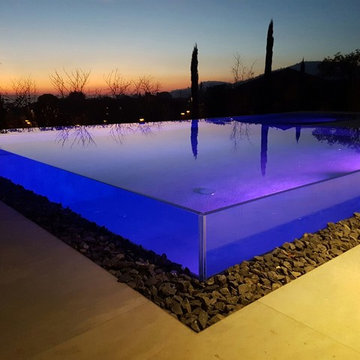 Piscina residenziale esterna con parete in vetro