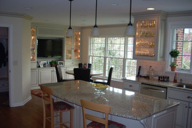 Large eclectic u-shaped medium tone wood floor and brown floor kitchen pantry photo in Other with shaker cabinets, white cabinets, granite countertops, white backsplash, porcelain backsplash, stainless steel appliances, an island and a double-bowl sink
