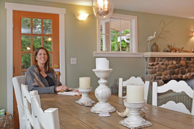This is an example of a mid-sized beach style dining room in Seattle with light hardwood floors and a stone fireplace surround.