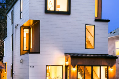 Example of a trendy white three-story wood exterior home design in Seattle