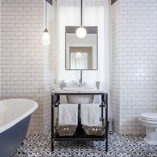 Inspiration for an industrial bathroom in Milan with a claw-foot bath, white tiles, metro tiles, a console sink, a one-piece toilet, recessed-panel cabinets and white cabinets.