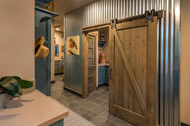 Example of a large country u-shaped slate floor and gray floor dedicated laundry room design in Other with a farmhouse sink, recessed-panel cabinets, blue cabinets, quartz countertops and beige walls