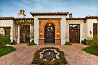 This is an example of a mediterranean one-storey stucco beige exterior in Phoenix.
